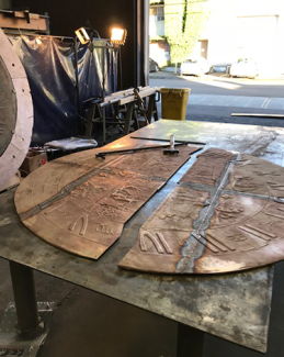 The sundial face lays in pieces waiting to be welded back into one solid peice.