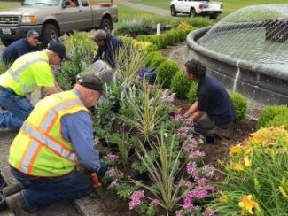 Workers planting flowers around Tivoli Fountain on the Capitol Campus.