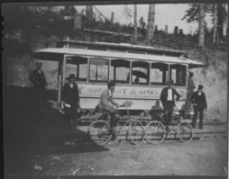 A historic photo of a trolley and people on bicycles in Tumwater. 