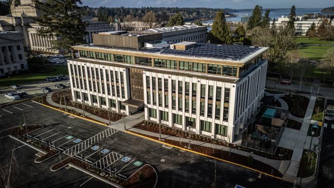 A bird's eye view of the Irving R. Newhouse Building, showing the new structure and parking lot, with the West Campus lawns and Capitol Group buildings visible in the background.