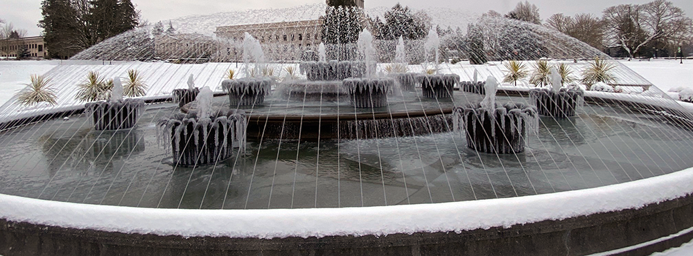 The Tivoli Fountain in a snowy setting shooting water streams into the air.