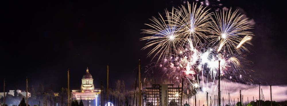 Fireworks explode in the night sky over Capitol Lake as part of the annnual Lakefair event