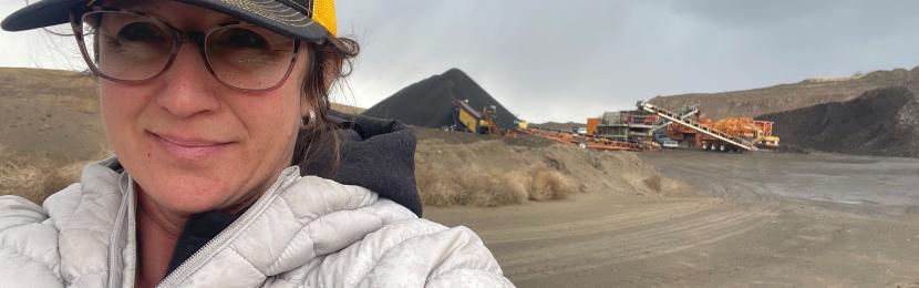 Cathleen Lovell in the foreground and heavy machine equipment in the background on-site. 