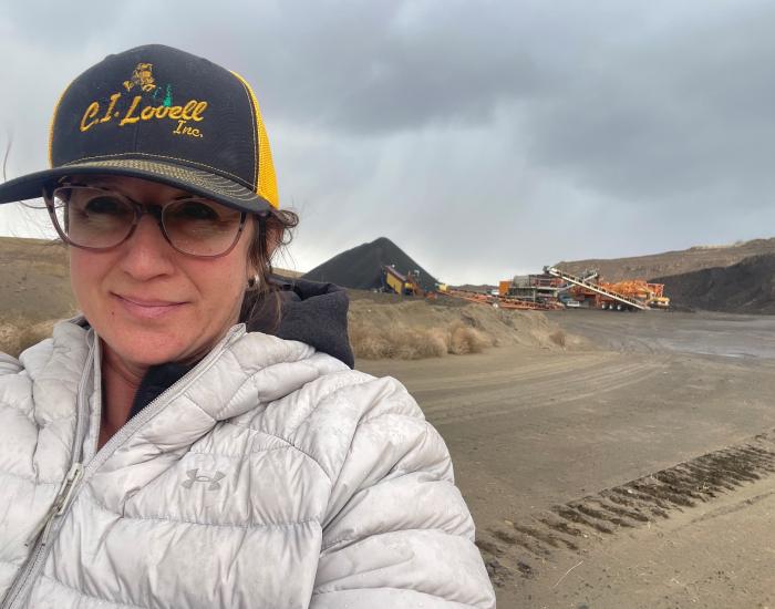 Cathleen Lovell in the foreground and heavy machine equipment in the background on-site. 