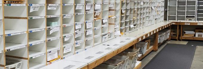 The mail room's sort wall containing hundreds of cubbies for incoming and outgoing mail.