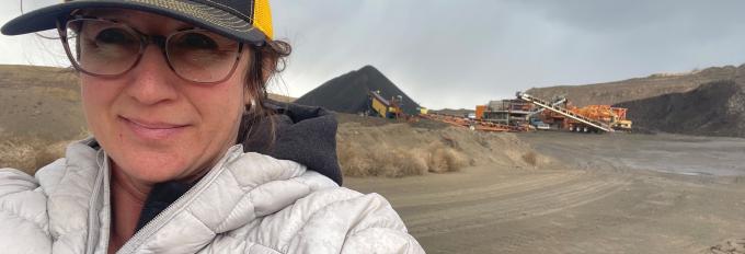 Cathleen Lovell in the foreground and heavy machine equipment in the background on-site.