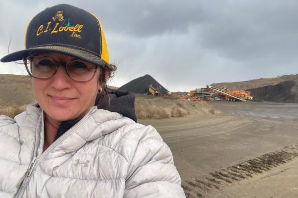 Cathleen Lovell in the foreground and heavy machine equipment in the background on-site.