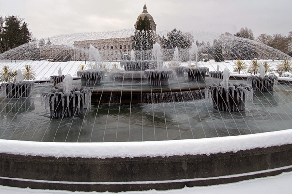 The Tivoli Fountain in a snowy setting shooting water streams into the air.