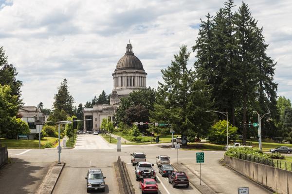 An image showing a traffic light with cars waiting to proceed toward the Capitol Building, which is in the background.