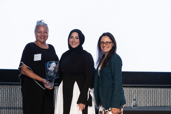 Pam Duncan (DES Deputy Director and Chief Transformation Officer), Huda Al-musawi (NWMMSDC Manager of Operations), and Kate Kleyman (NWMMSDC Board Vice Chairperson and Senior Program Manager at McKinstry) pose for a picture with the award for DES. 
